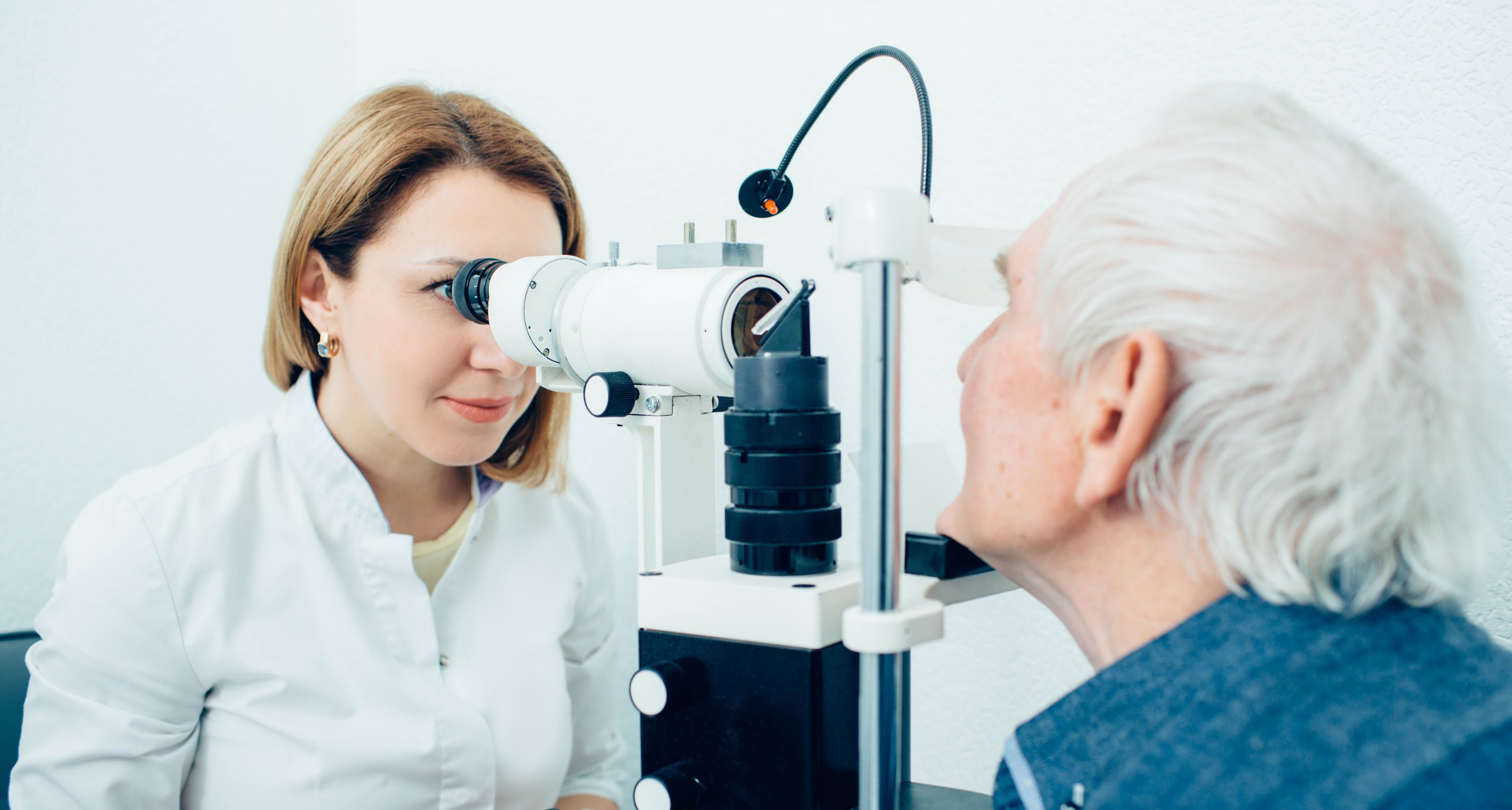 Senior man visiting optician, eye exam at clinic Auscultation-sénior